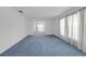 Spacious living room featuring neutral walls, classic carpeting, and abundant natural light at 7002 Doreen St, Tampa, FL 33617