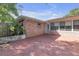 An outdoor patio featuring a brick building with a small garden area and an enclosed porch area at 7002 Doreen St, Tampa, FL 33617