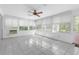 Inviting sunroom with tile flooring, multiple windows, and a ceiling fan at 7002 Doreen St, Tampa, FL 33617