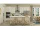 Modern kitchen with white cabinets, stainless steel appliances, and a center island with seating at 7546 E 117Th Ln, Palmetto, FL 34221