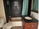 Bathroom with a shower-tub combo, toilet, and a dark vanity at 7806 N Orleans Ave, Tampa, FL 33604