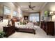 Bright main bedroom featuring ceiling fan, decorative windows, lamps and matching nightstands at 841 Ponce De Leon Dr, St Petersburg, FL 33715
