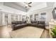 Spacious living room with high ceilings, large sectional sofa, and an abundance of natural light at 8460 Capstone Ranch Dr, New Port Richey, FL 34655