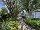 View of detached garage and patio area shaded by mature trees at 8502 N Branch Ave, Tampa, FL 33604