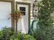 Close up of the house's side door with potted plants and a green garden hose at 8502 N Branch Ave, Tampa, FL 33604