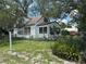 White home featuring a fenced yard with beautiful vegetation at 8502 N Branch Ave, Tampa, FL 33604