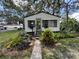 Home with manicured front yard featuring well-maintained landscaping and stone walkway at 8502 N Branch Ave, Tampa, FL 33604