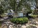View of detached garage and patio area shaded by mature trees at 8502 N Branch Ave, Tampa, FL 33604