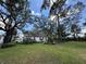Quaint home with a well-manicured lawn and mature trees providing ample shade, nestled beneath a partly cloudy sky at 8502 N Branch Ave, Tampa, FL 33604