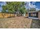 Spacious backyard with a wooden fence and a covered patio, offering ample space at 9100 Lunar Ln, Port Richey, FL 34668