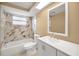 Bright bathroom featuring a modern vanity, updated marble tile, and a shower-tub combination at 9100 Lunar Ln, Port Richey, FL 34668