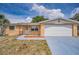 Charming single-story home featuring a front yard, attached garage, and desert-friendly landscaping at 9100 Lunar Ln, Port Richey, FL 34668