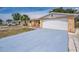 Charming single-story home featuring a driveway, attached garage, and desert-friendly landscaping at 9100 Lunar Ln, Port Richey, FL 34668