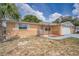 Charming single-story home featuring a front yard, attached garage, and desert-friendly landscaping at 9100 Lunar Ln, Port Richey, FL 34668