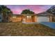 Charming single-story home featuring a front yard, attached garage, and desert-friendly landscaping at 9100 Lunar Ln, Port Richey, FL 34668
