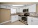 Updated kitchen with stainless steel appliances, modern backsplash, and white cabinets at 9100 Lunar Ln, Port Richey, FL 34668