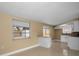 An open-concept living room with large window and sliding glass doors, blending with the white kitchen at 9100 Lunar Ln, Port Richey, FL 34668