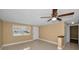 Bright living room with a large window, tile floors, and a ceiling fan at 9100 Lunar Ln, Port Richey, FL 34668