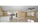 Inviting living room blending into the kitchen with white cabinets and bar-style seating beneath modern lighting at 9100 Lunar Ln, Port Richey, FL 34668
