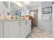 Well-lit bathroom features a white vanity, marble floors, and glass shower door at 9276 Ashley Dr, Weeki Wachee, FL 34613