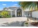 Beautiful home with double door entrance, arched windows, white columns, and paved driveway at 9276 Ashley Dr, Weeki Wachee, FL 34613