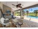 Covered patio with wicker furniture offers a view of the pool and green yard at 9276 Ashley Dr, Weeki Wachee, FL 34613