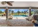 Covered patio provides a view of the screened-in pool and well-manicured lawn at 9276 Ashley Dr, Weeki Wachee, FL 34613