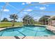 Screened in pool area with a palm tree and well manicured lawn and landscaping at 9276 Ashley Dr, Weeki Wachee, FL 34613