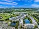 Expansive aerial view of condos nestled within lush greenery, golf course, waterways, and community pool at 960 Starkey Rd # 9104, Largo, FL 33771