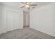Carpeted bedroom with ceiling fan features a double door closet for ample storage space at 9828 Branching Ship Trace, Wesley Chapel, FL 33545