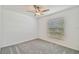Bright bedroom featuring soft gray carpet, a ceiling fan, and a window with horizontal blinds at 9828 Branching Ship Trace, Wesley Chapel, FL 33545