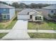 Well-maintained single-Gathering home with a manicured lawn and an attached two-car garage at 9828 Branching Ship Trace, Wesley Chapel, FL 33545