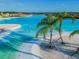 Beautiful lagoon view with white sand beaches, turquoise water and palm trees creating a tropical oasis at 9828 Branching Ship Trace, Wesley Chapel, FL 33545