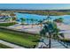 Aerial view of the community's lagoon showcasing a sandy beach, palm trees, and turquoise water at 9828 Branching Ship Trace, Wesley Chapel, FL 33545