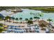 Aerial view of the lagoon featuring a sandy beach, lounge chairs, and various water activities at 9828 Branching Ship Trace, Wesley Chapel, FL 33545