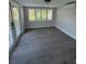 Bright living room featuring wood-look floors, white trim and window shutters and glass doors to exterior at 6034 Bayou Grande Ne Blvd, St Petersburg, FL 33703
