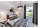 Cozy bedroom features stylish decor, a modern light fixture, and a bright window at 10486 Sea Breeze Ridge Dr, Englewood, FL 34223