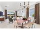 Open-concept dining room with modern chandelier, connecting living room and patio at 10486 Sea Breeze Ridge Dr, Englewood, FL 34223