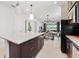 Open-concept kitchen with island seating, dark cabinets, and view to living and dining area at 10486 Sea Breeze Ridge Dr, Englewood, FL 34223