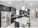 Modern kitchen with stainless steel appliances, a spacious island, and dark cabinetry at 10486 Sea Breeze Ridge Dr, Englewood, FL 34223
