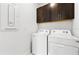 Bright laundry room with dark cabinets over the washer and dryer for storage at 10486 Sea Breeze Ridge Dr, Englewood, FL 34223