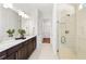 Modern main bathroom features a glass enclosed shower, double sink vanity, and ample lighting at 10486 Sea Breeze Ridge Dr, Englewood, FL 34223