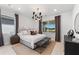 Charming bedroom featuring stylish decor, a modern light fixture, and a large window at 10486 Sea Breeze Ridge Dr, Englewood, FL 34223