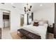 Comfortable bedroom with a modern light fixture and ensuite bathroom entrance at 10486 Sea Breeze Ridge Dr, Englewood, FL 34223