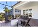 Large screened patio with outdoor seating and dining areas overlooking the backyard at 10486 Sea Breeze Ridge Dr, Englewood, FL 34223