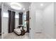 Bright sitting area features a small chaise, side table, and natural lighting from two large windows at 10486 Sea Breeze Ridge Dr, Englewood, FL 34223