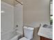 Bathroom featuring a bathtub, showerhead, toilet, and marble countertop at 10515 Canary Isle Dr, Tampa, FL 33647
