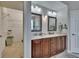 Double vanity bathroom with wood cabinets, framed mirrors and a walk-in closet at 10515 Canary Isle Dr, Tampa, FL 33647