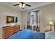 Bedroom with television, curtains, and bed with a blue comforter at 10515 Canary Isle Dr, Tampa, FL 33647
