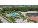 Aerial view of the community pool, sandy beach, and nearby amenities amidst lush greenery at 10515 Canary Isle Dr, Tampa, FL 33647
